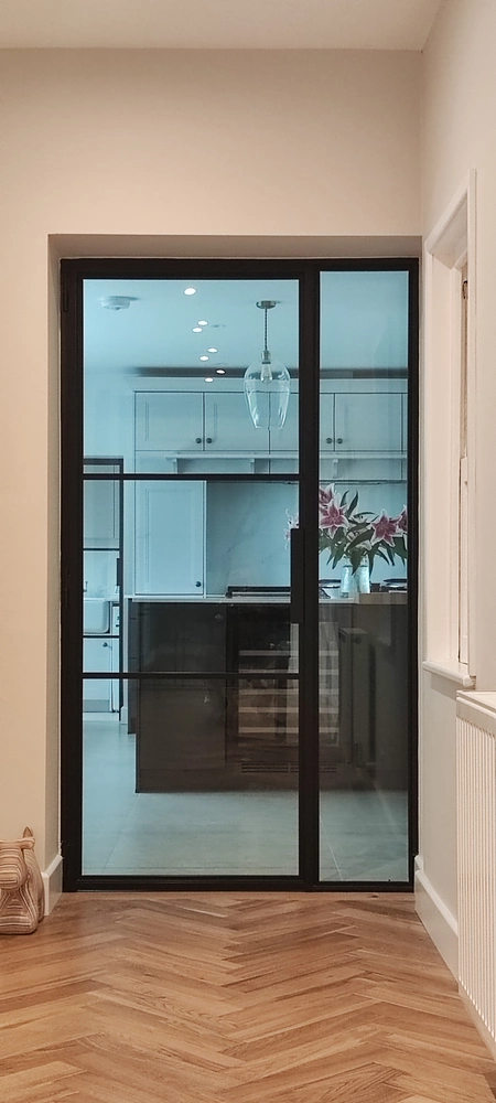 kitchen separated by steel crittall doors and glass panels