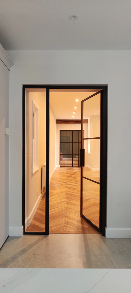 hallway with bifold crittall doors and warm lighting