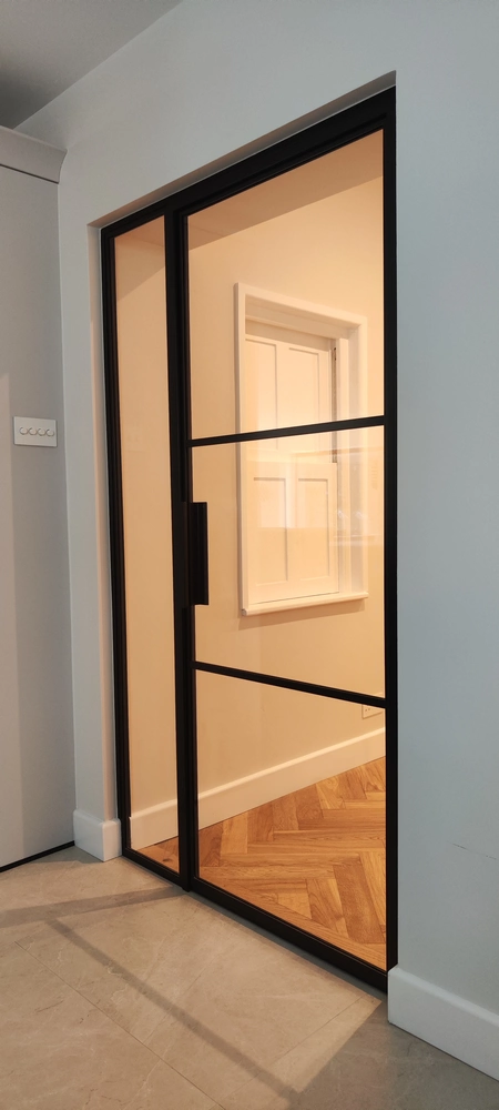 corridor with crittall internal doors and a soft beige wall