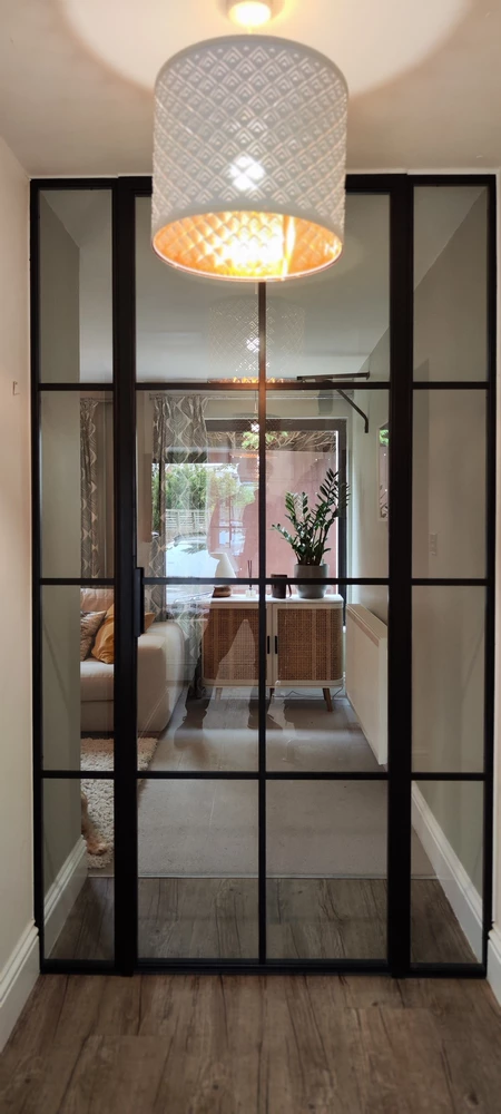 living room with crittall style internal doors and a floral arrangement